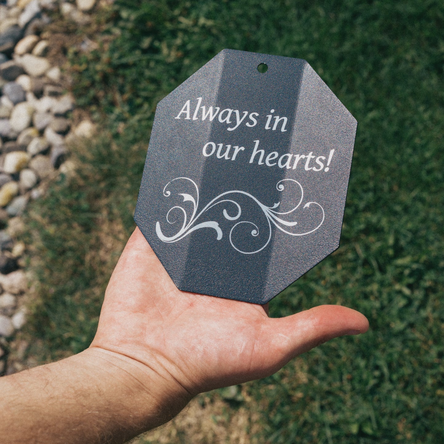 Close-up of a custom engraved wind chime sail with the message 'Always in our hearts!' and decorative scrollwork, perfect for a sympathy or bereavement gift.