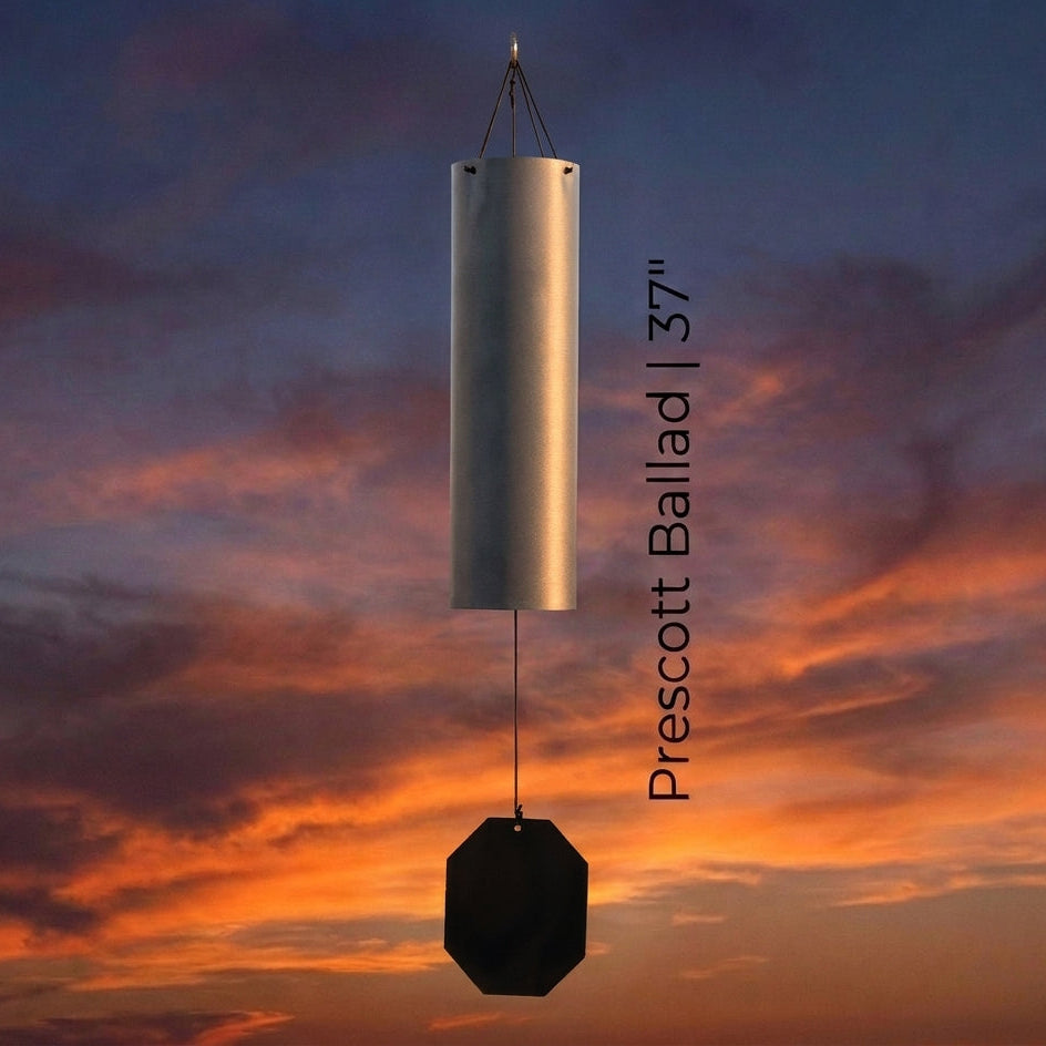 Lambright Country Chimes Prescott Ballad 37-inch Amish handcrafted wind bell with silver finish and octagonal clapper against a sunset sky