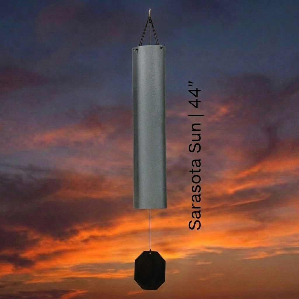 Lambright Country Chimes Sarasota Sun 44-inch Amish handcrafted wind bell with silver finish and octagonal clapper against a sunset sky